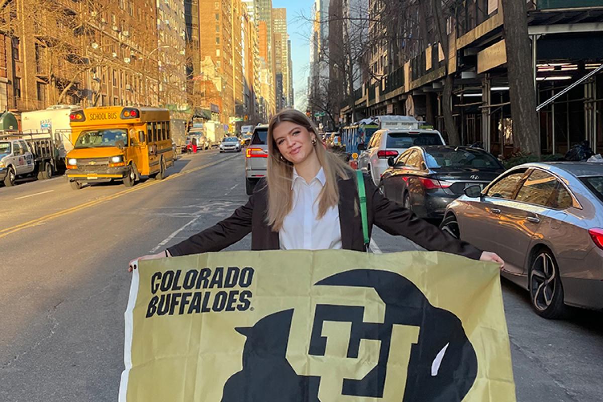 Lily holds a Buffs flag in midtown Manhattan.