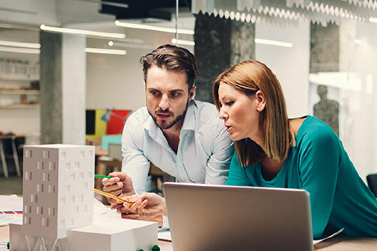 Real estate professionals looking at models of commercial buildings