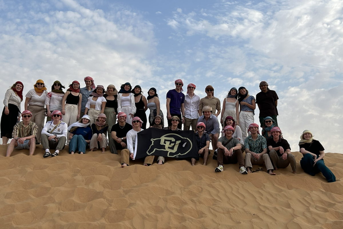 Business students pose with a CU flag in Dubai during their FGX trip.