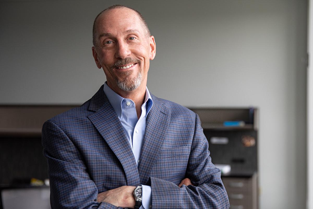 Curtis Sears in professional attire smiles for the camera in a learning lab.