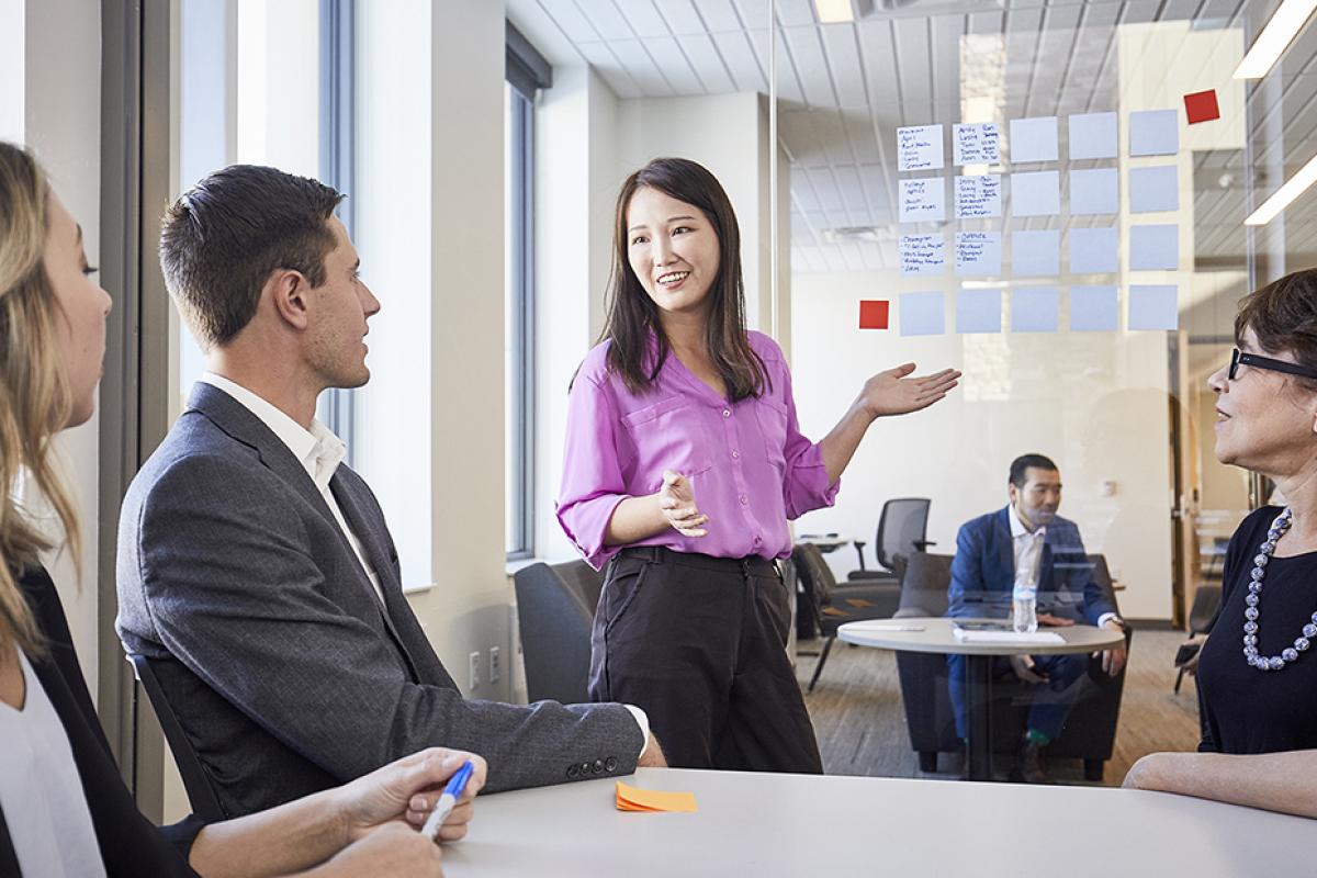 A female student leads a small-group discussion.