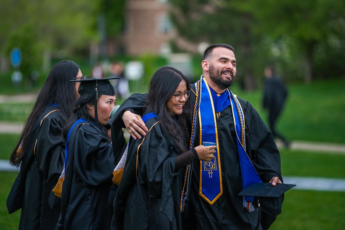 Graduates laugh together during the reception held before the graduate graduation ceremony.