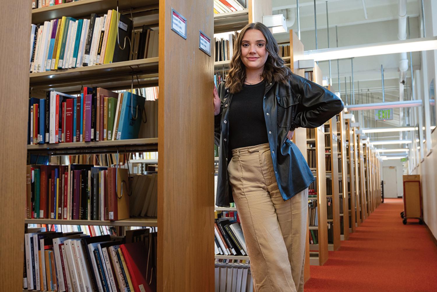 Chloe Theil stands in a library