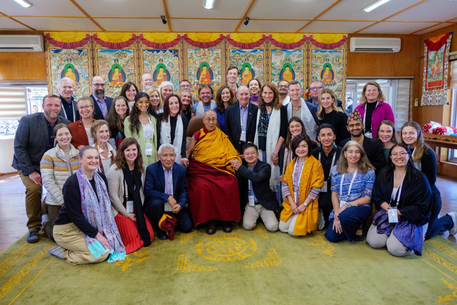 Group photo of college students and school representatives with the Dalai Lama