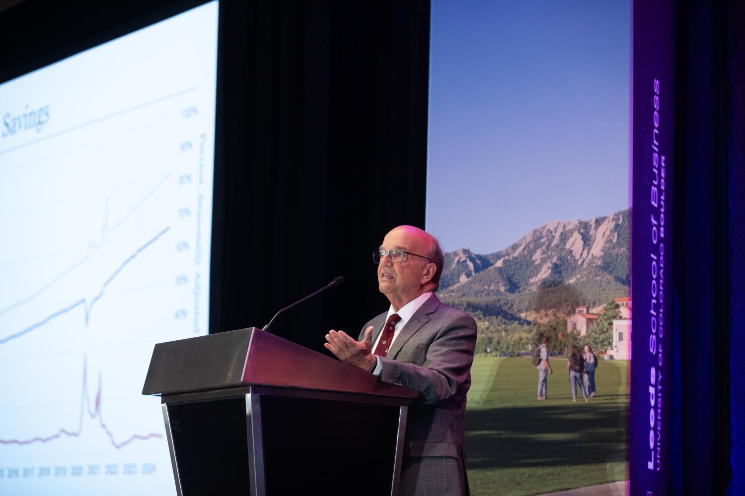 Rich Wobbekind speaks from a podium at the 2025 Colorado Business Economic Outlook Forum