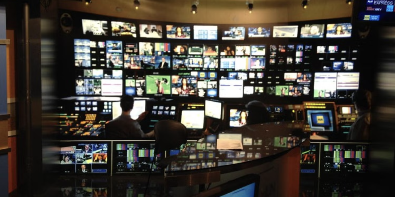 Video control room with numerous screens showing different programs