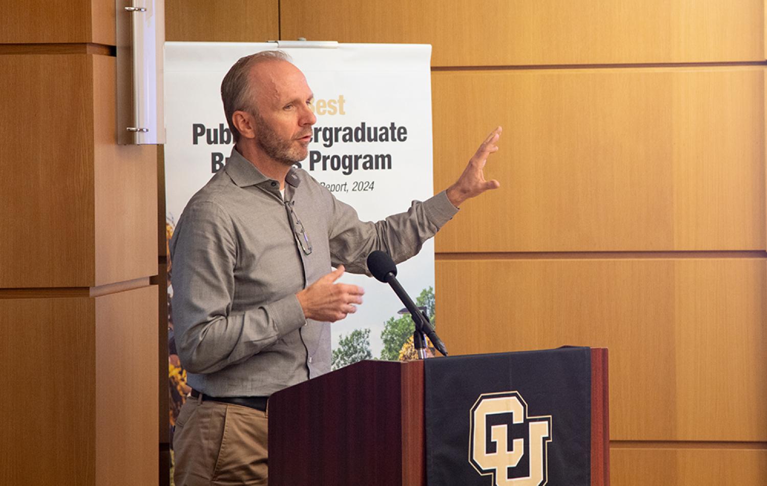 Kai Larsen speaks from a podium