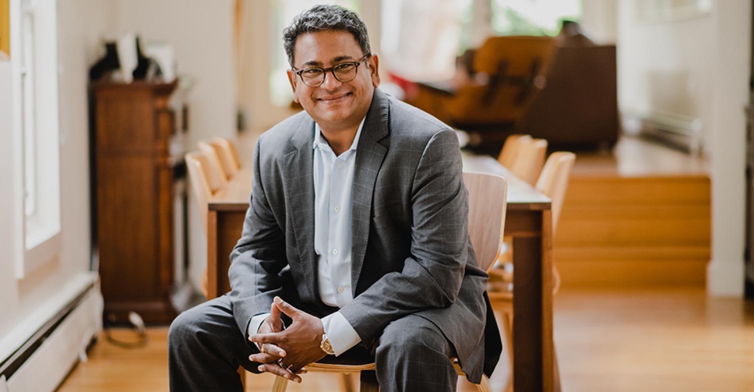 Ashish Kothari, in business attire, smiles in his home.