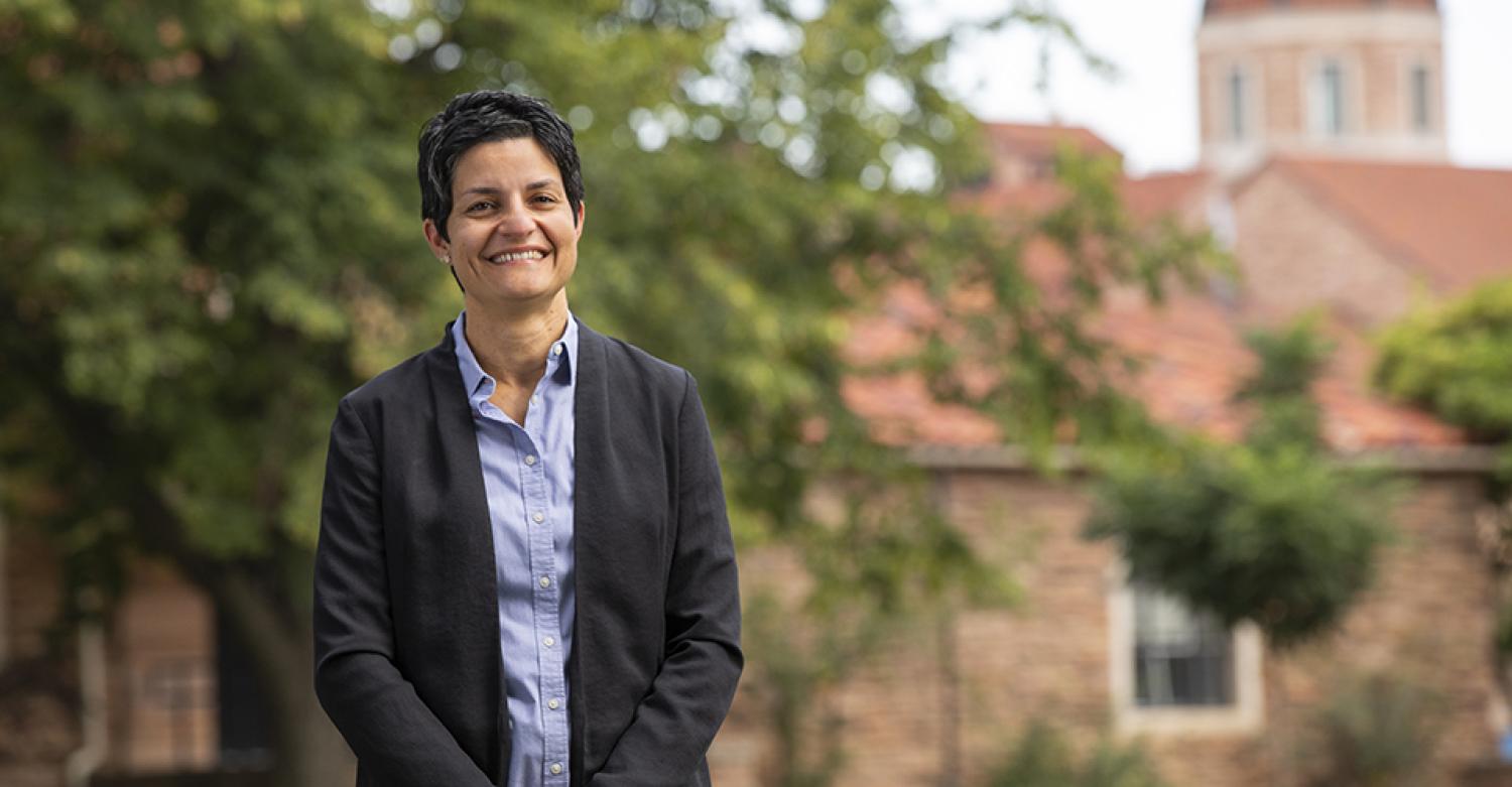 Yonca Ertimur poses outside of the Koelbel Building in professional attire.