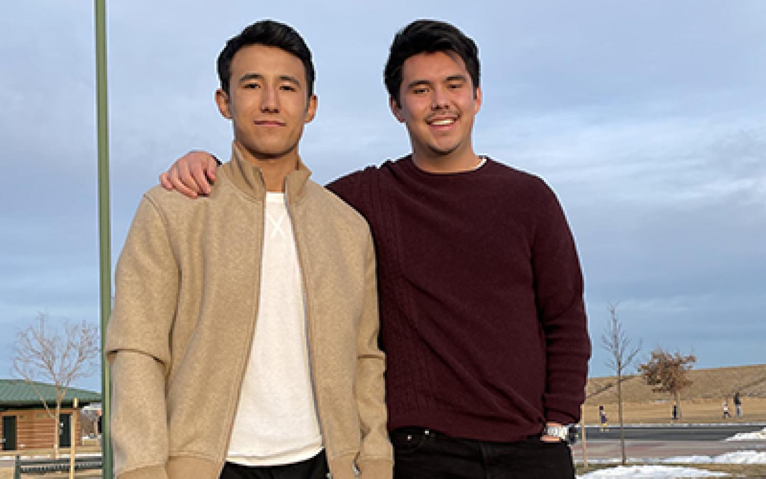 Sam, left, and Kai pose for a photo outdoors.
