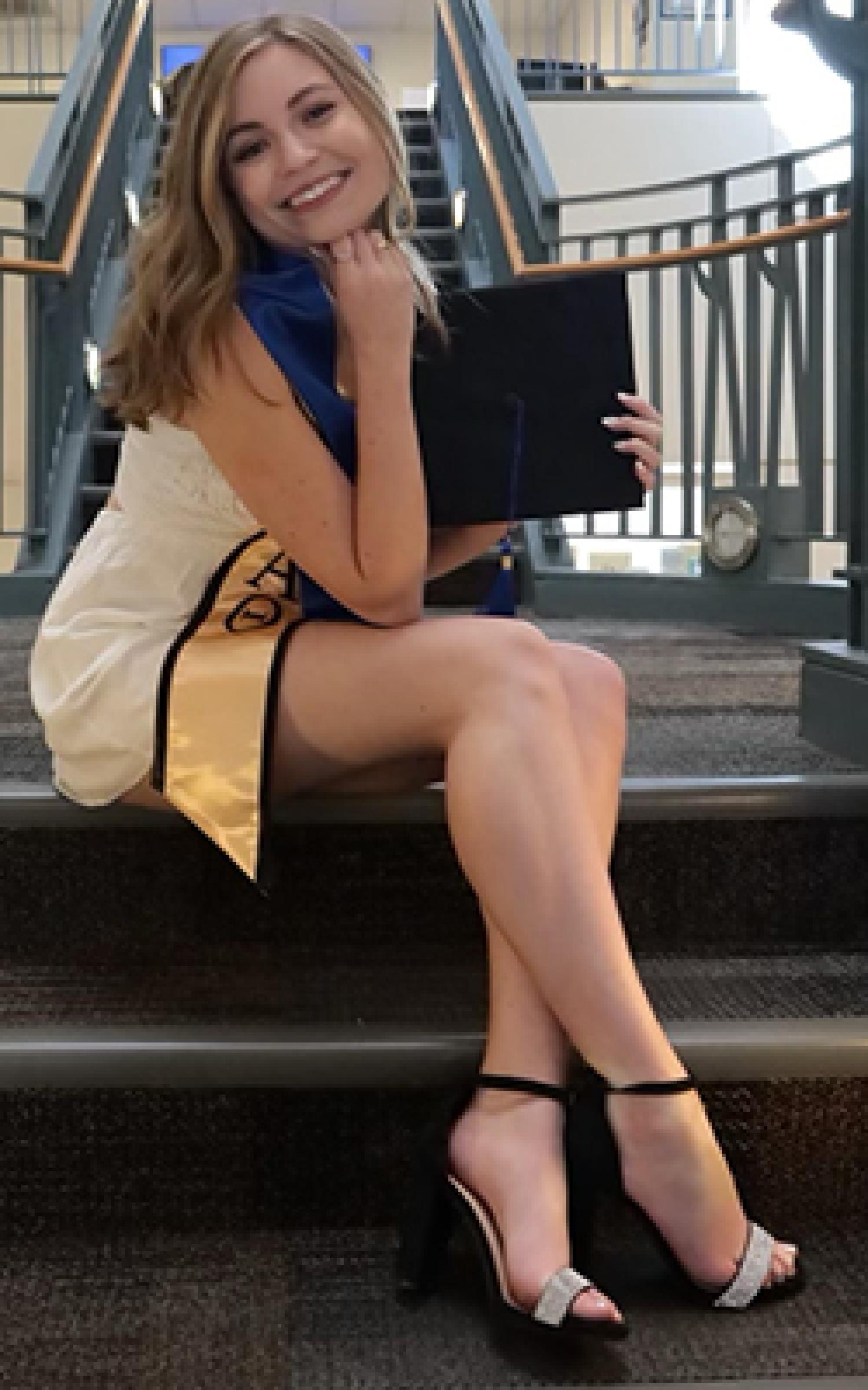 Olivia in her graduation regalia in the main reception of Koelbel.