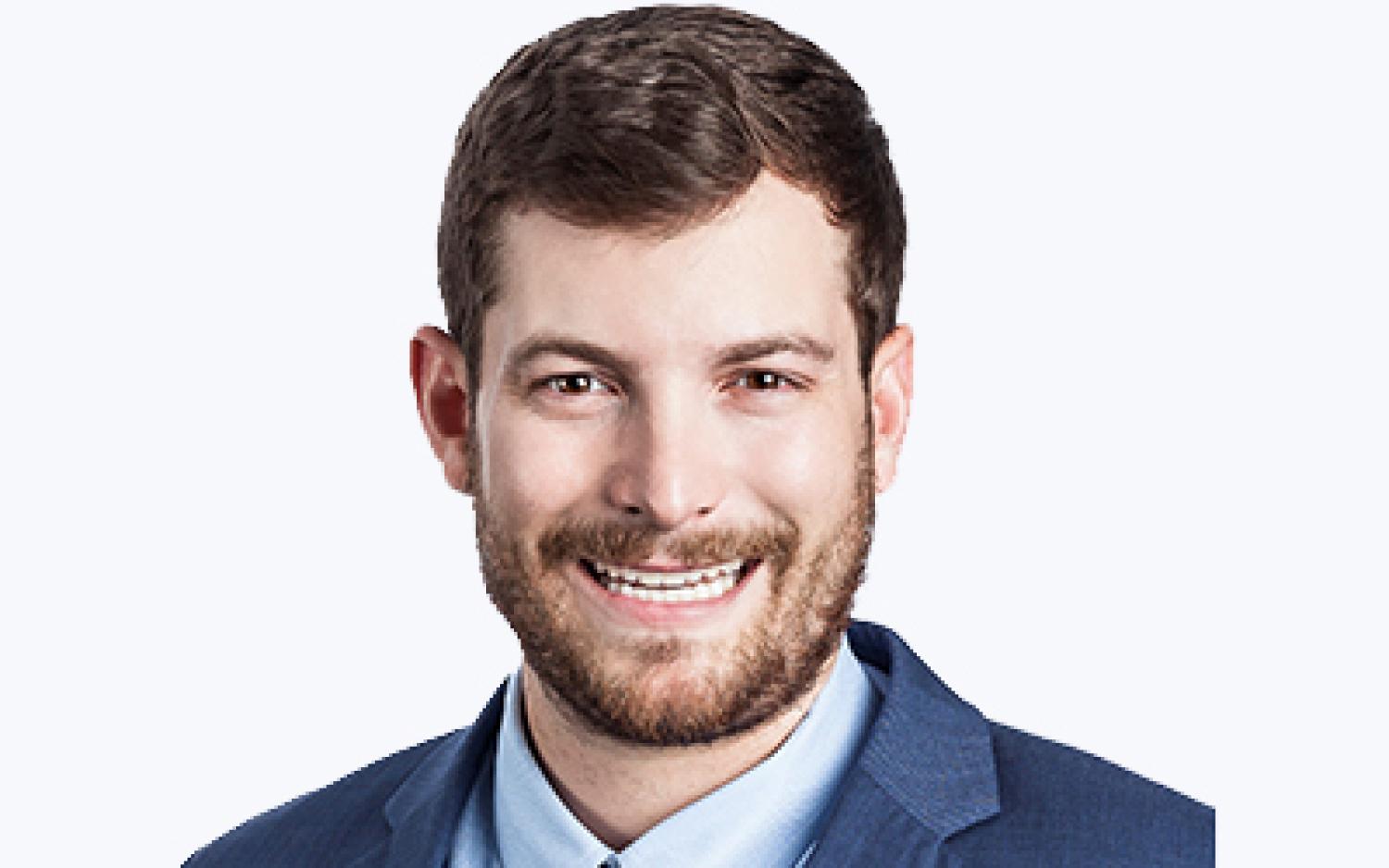 Headshot of Tommy Marlier in a blue suit.