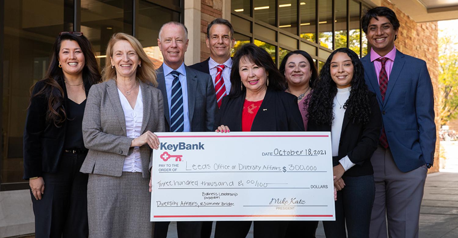 A group of professionals and students poses with a check from KeyBank to support diversity initiatives at Leeds.