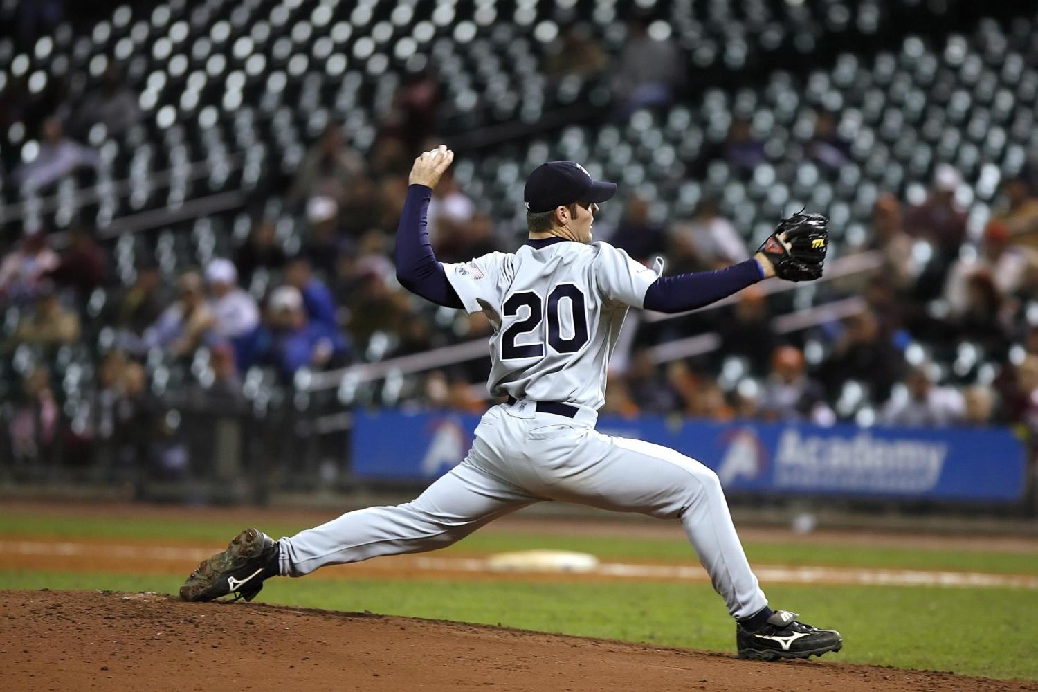 A baseball pitcher in No. 20 jersey readies to throw the ball.
