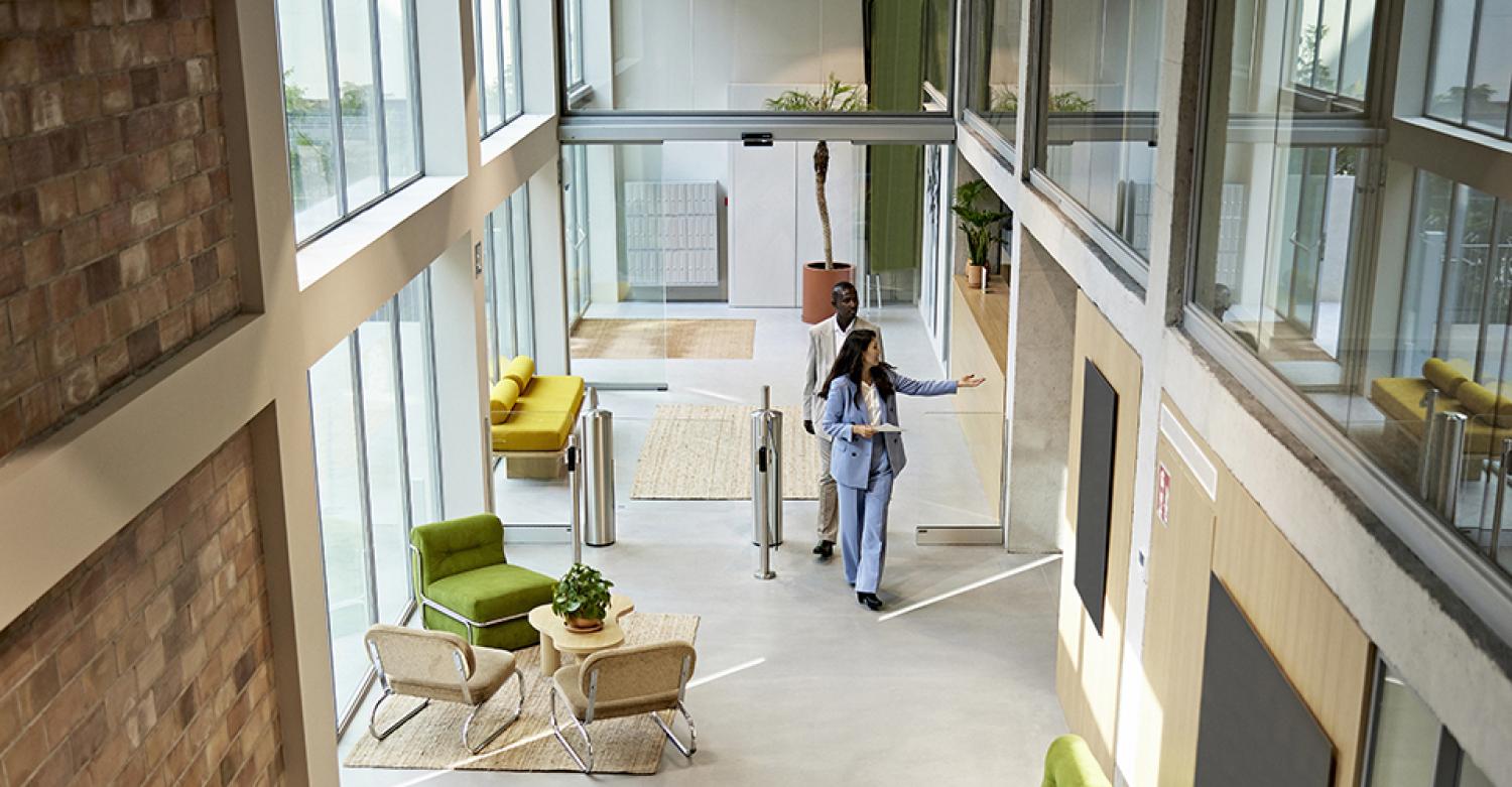 A woman shows a modern office space to a professional.