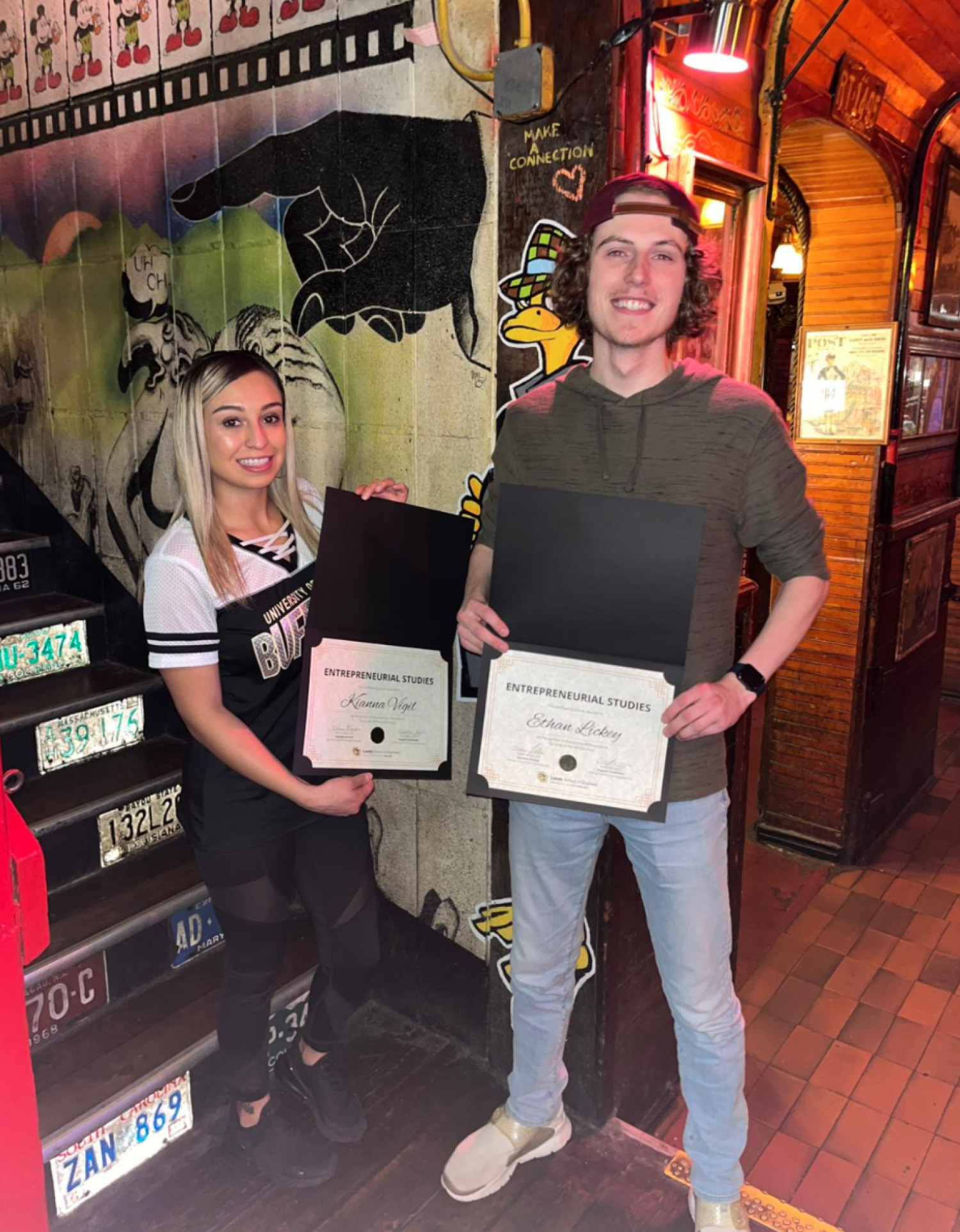 Two students holding their entrepreneurship certificate