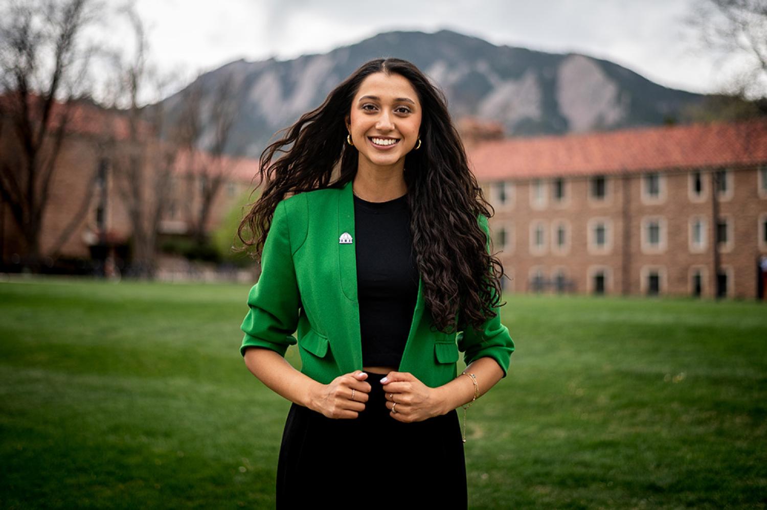 Trisha Tyagi smiles at the camera while posing on campus.