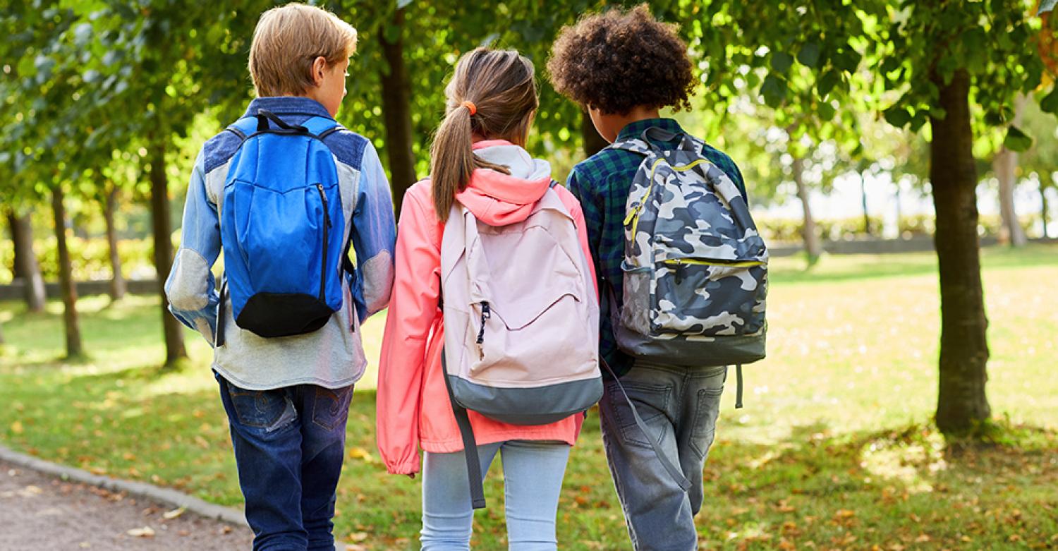 elementary school students walking away from the camera