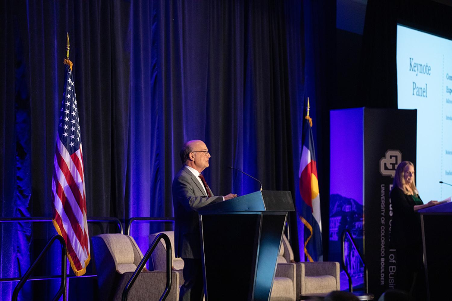 Rich Wobbekind speaks from behind a podium during the 2024 Business Economic Outlook Forum.