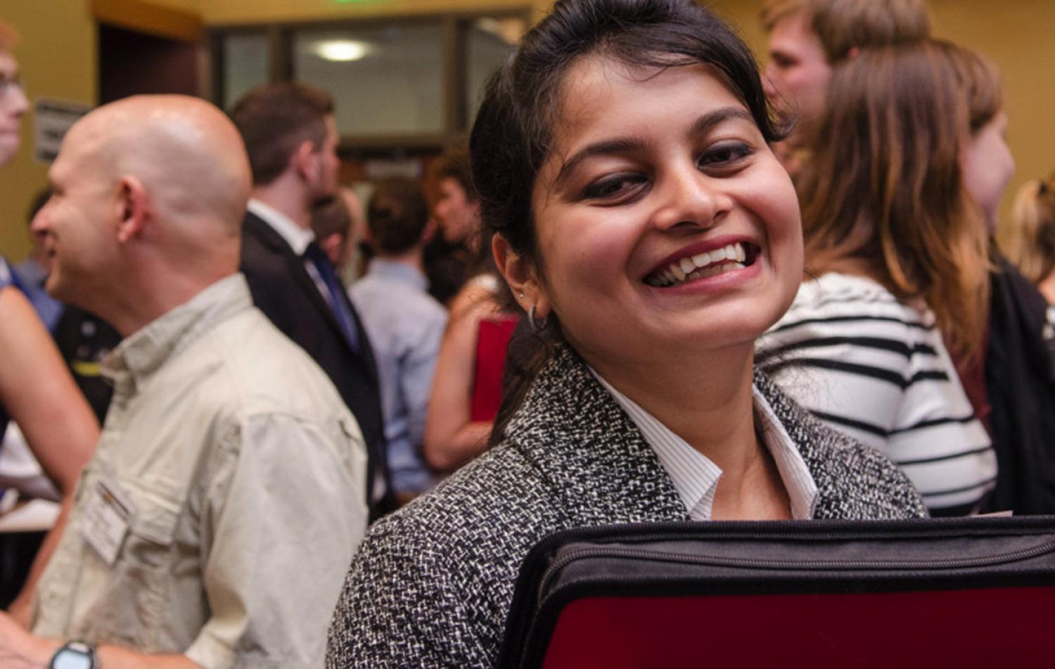 Female business student smiling with group of other MBA students