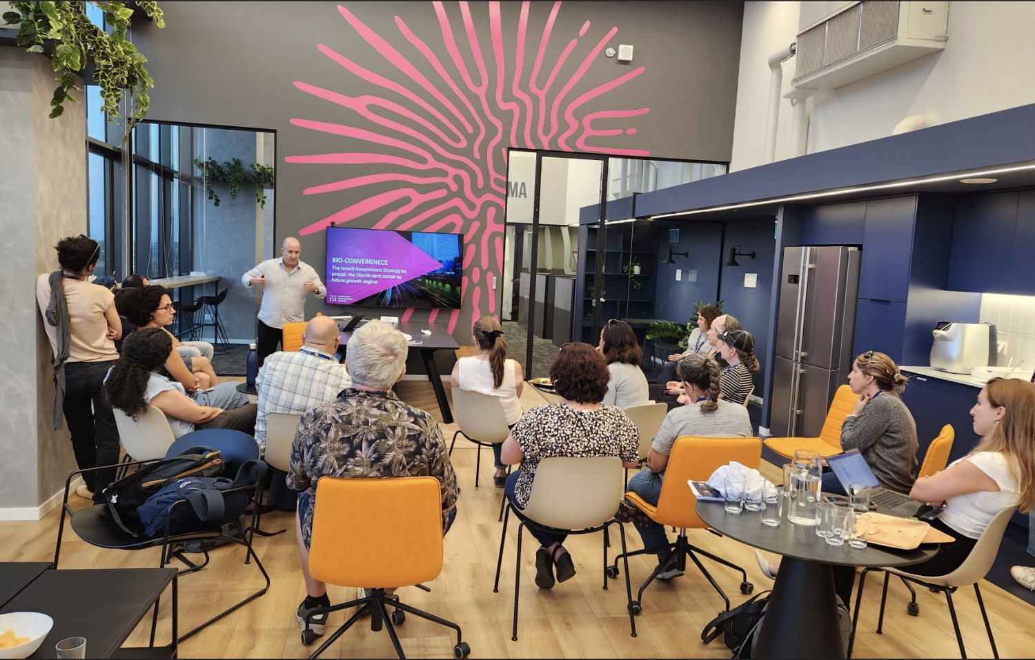 Group of executives seated listening to a presentation in a colorful room