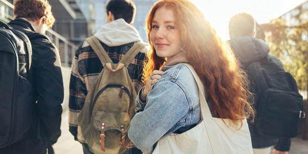 A woman in a group of students looks over her shoulder at the camera. 