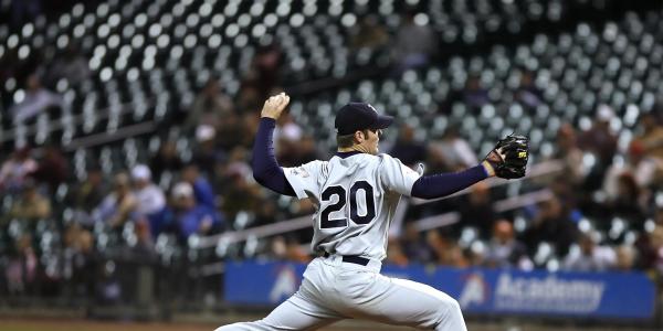 A baseball pitcher in No. 20 jersey readies to throw the ball.