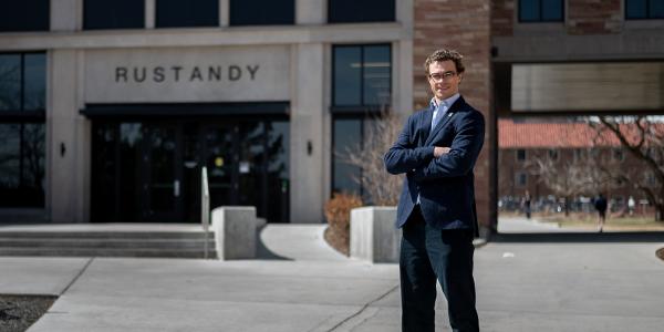 Renner Skidmore poses with his arm crossed in front of the Rustandy Building.