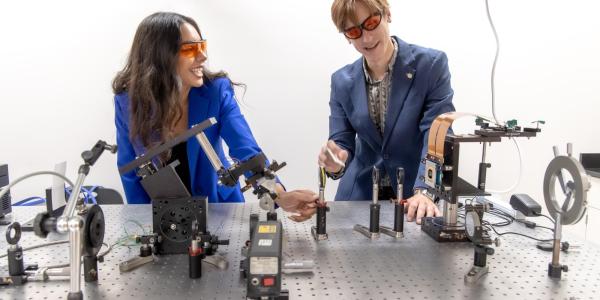 Camila Uzcategui and Johnny Hergert laugh while working in their materials lab.