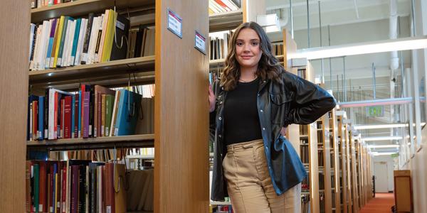 Chloe Theil stands in a library