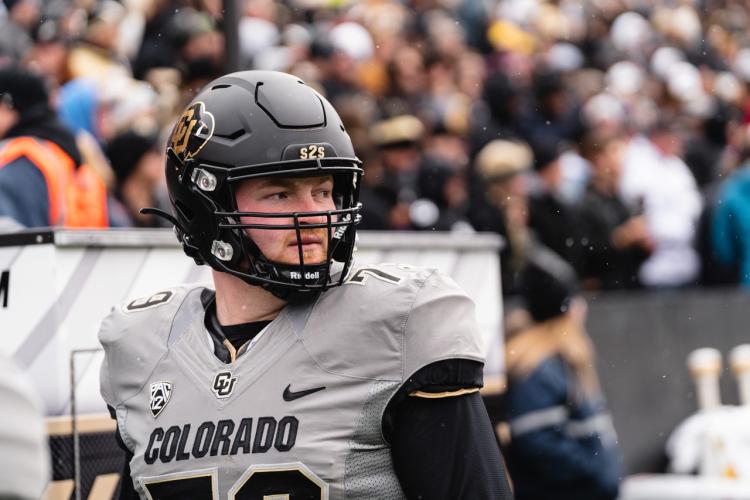 Camden Dempsey looks out of frame while geared up during a CU football game.