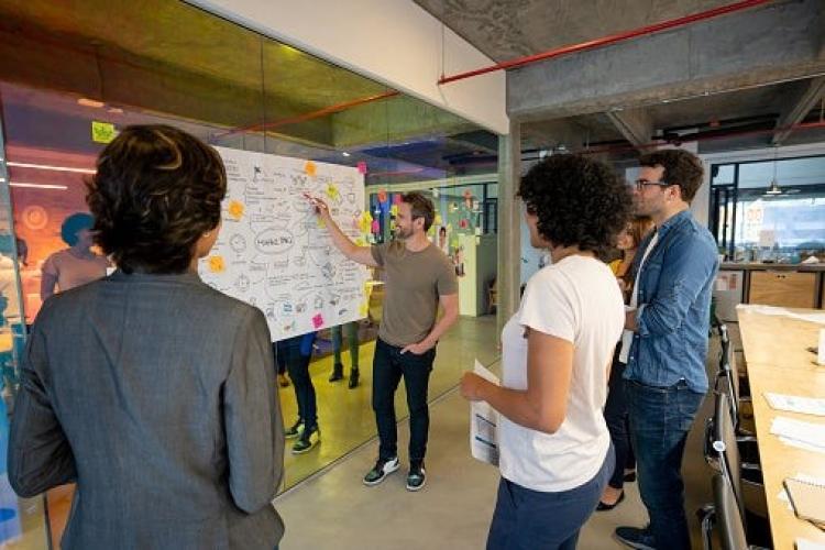 Group of professionals brainstorming around a whiteboard
