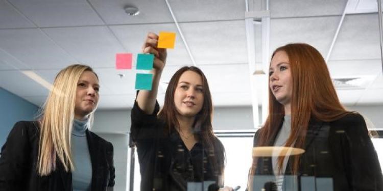 Group of students deciding on topics using post-it notes
