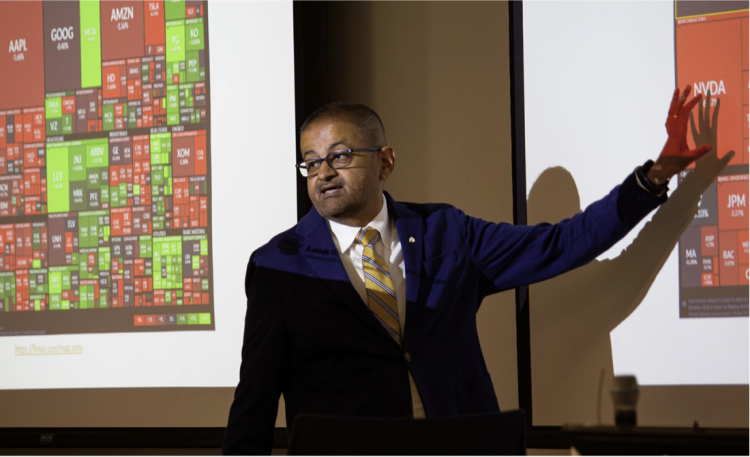 Dean Vijay Khatri stands in front of a projected screen gesturing