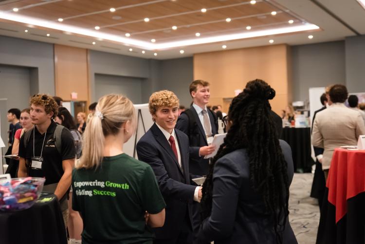 Student at a table meeting people at the Career Fair