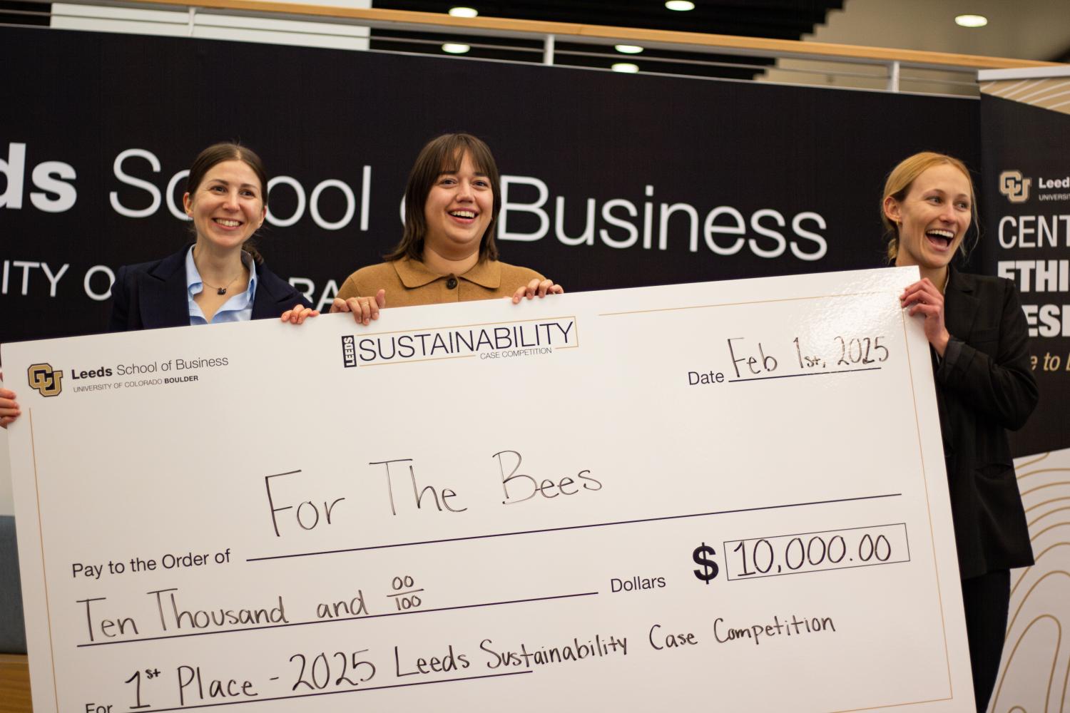 Winners Smiling and Holding Up Huge Check
