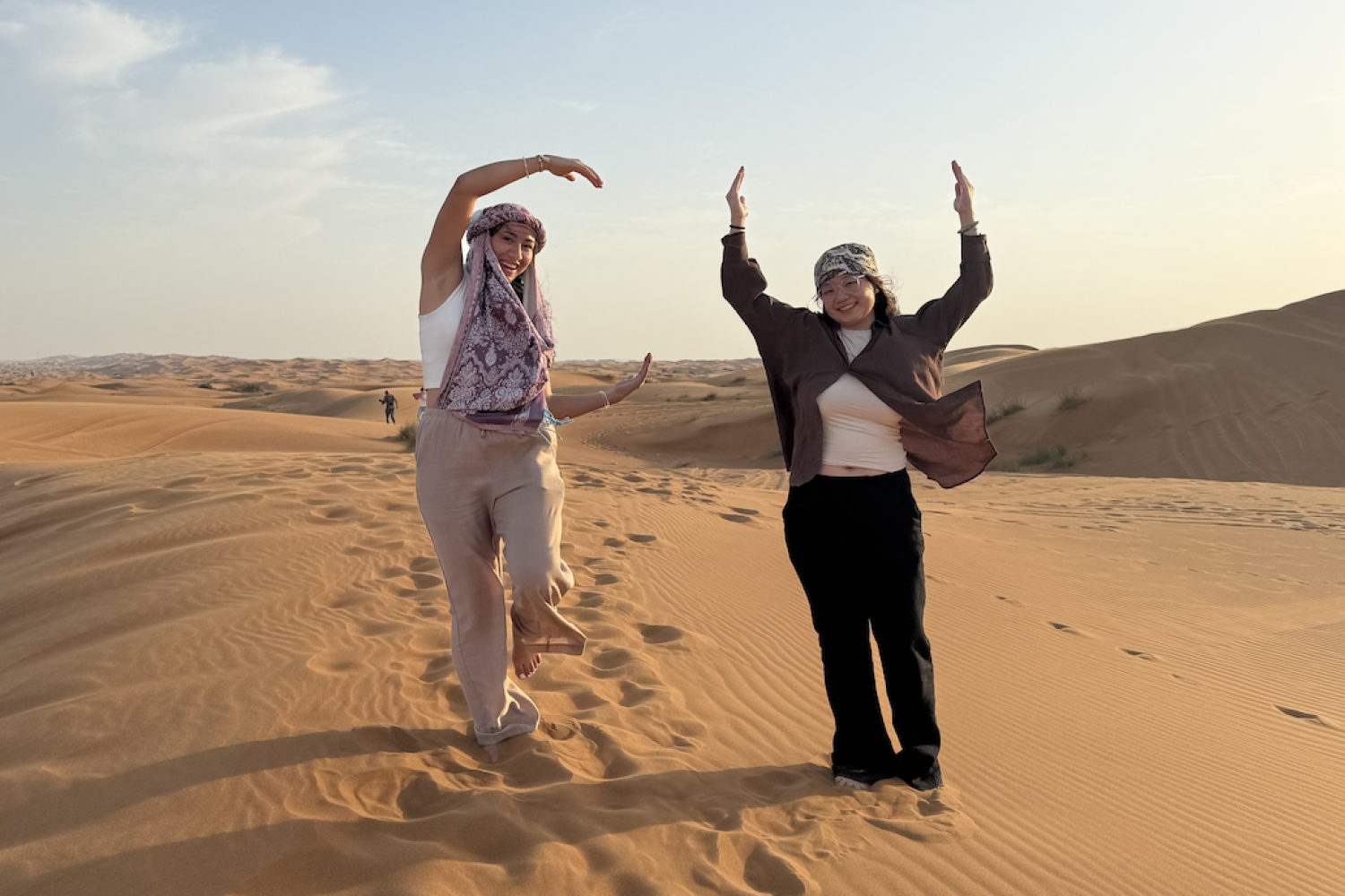 Students standing in a desert spell out "CU" with their arms