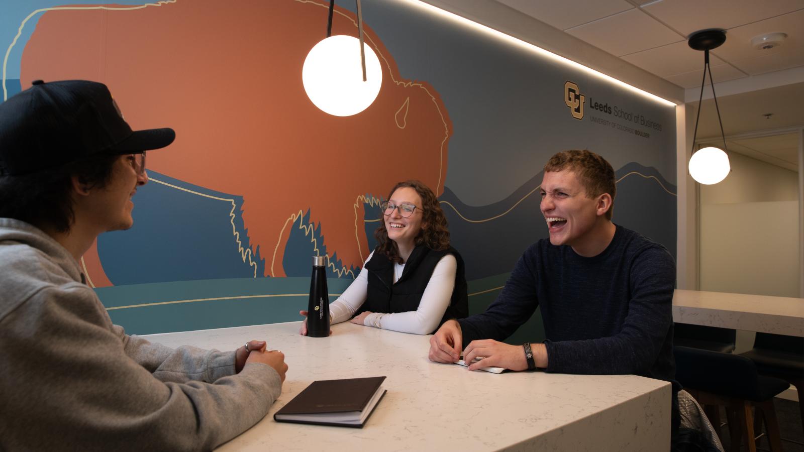 Students laugh while working at a table