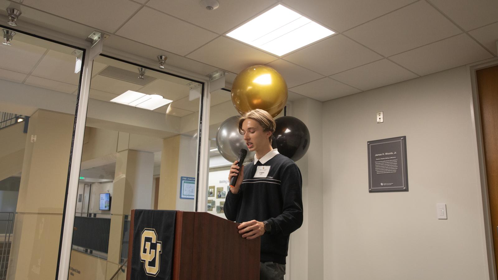 Logan Gero speaks at a podium