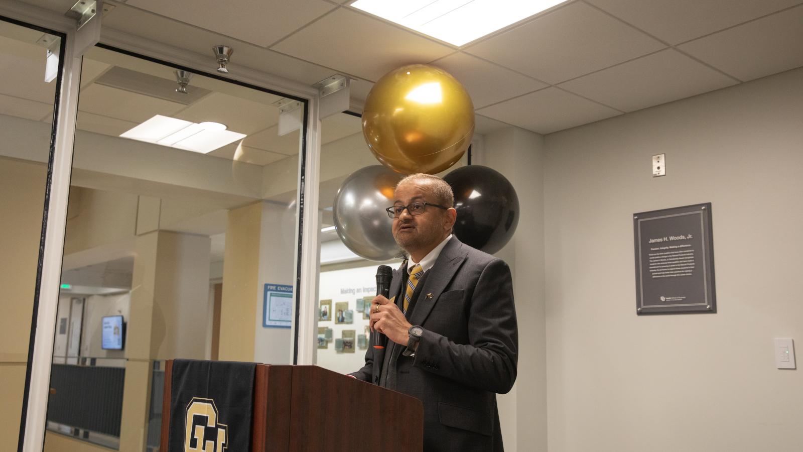 Dean Vijay Khatri speaks at a podium