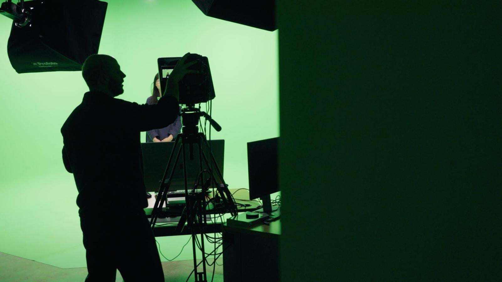 Green screen with a person working a camera in shadow
