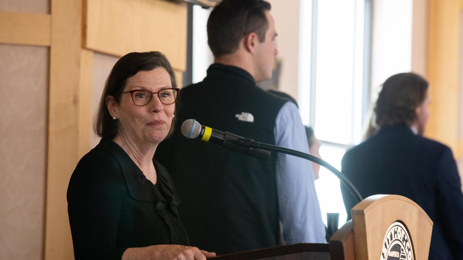 Sheila Duffy speaks from a podium during Burridge's spring celebration.