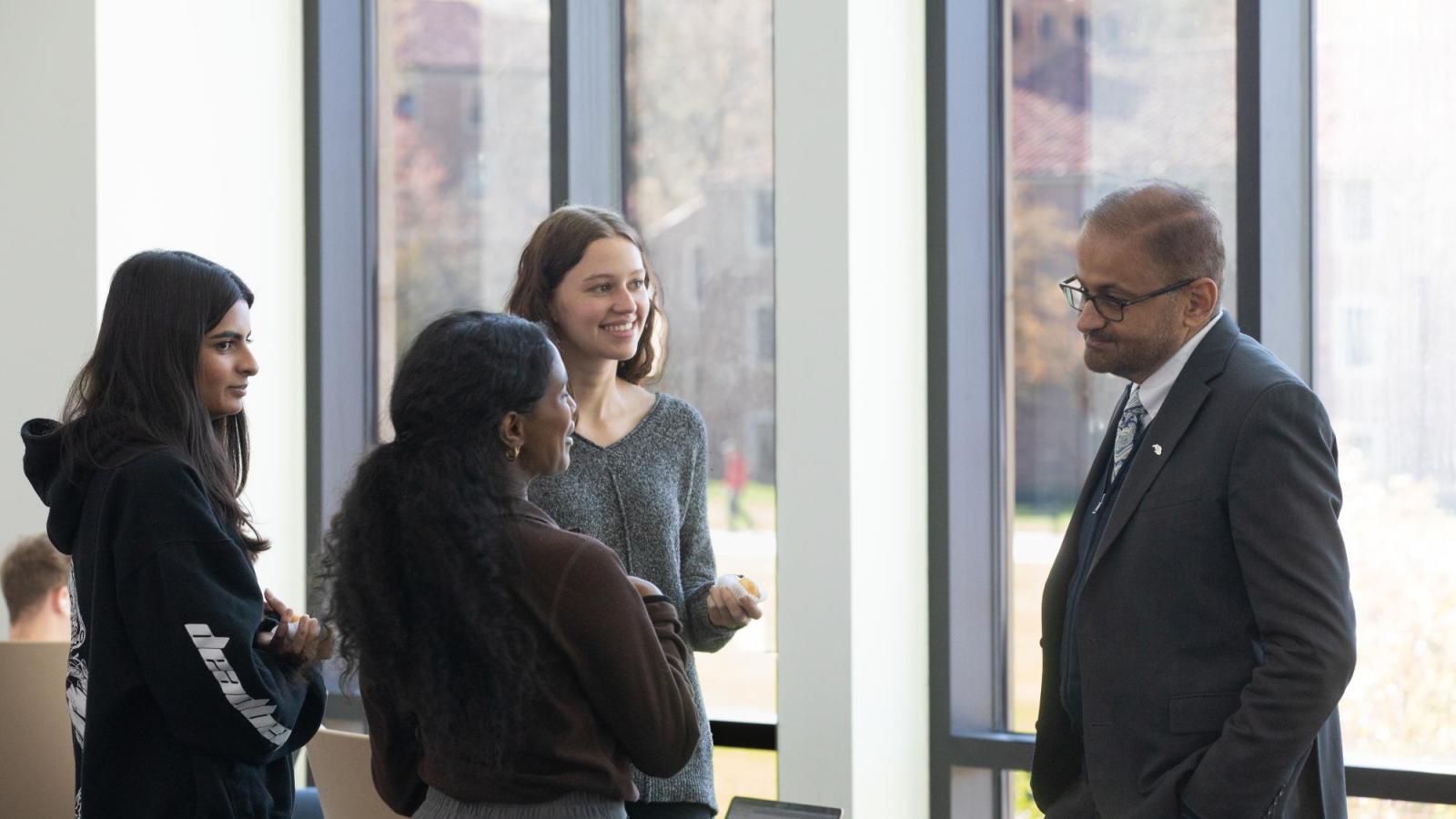 Dean Vijay Khatri chats with a group of students in the Olson Atrium during a Donuts with the Dean event.