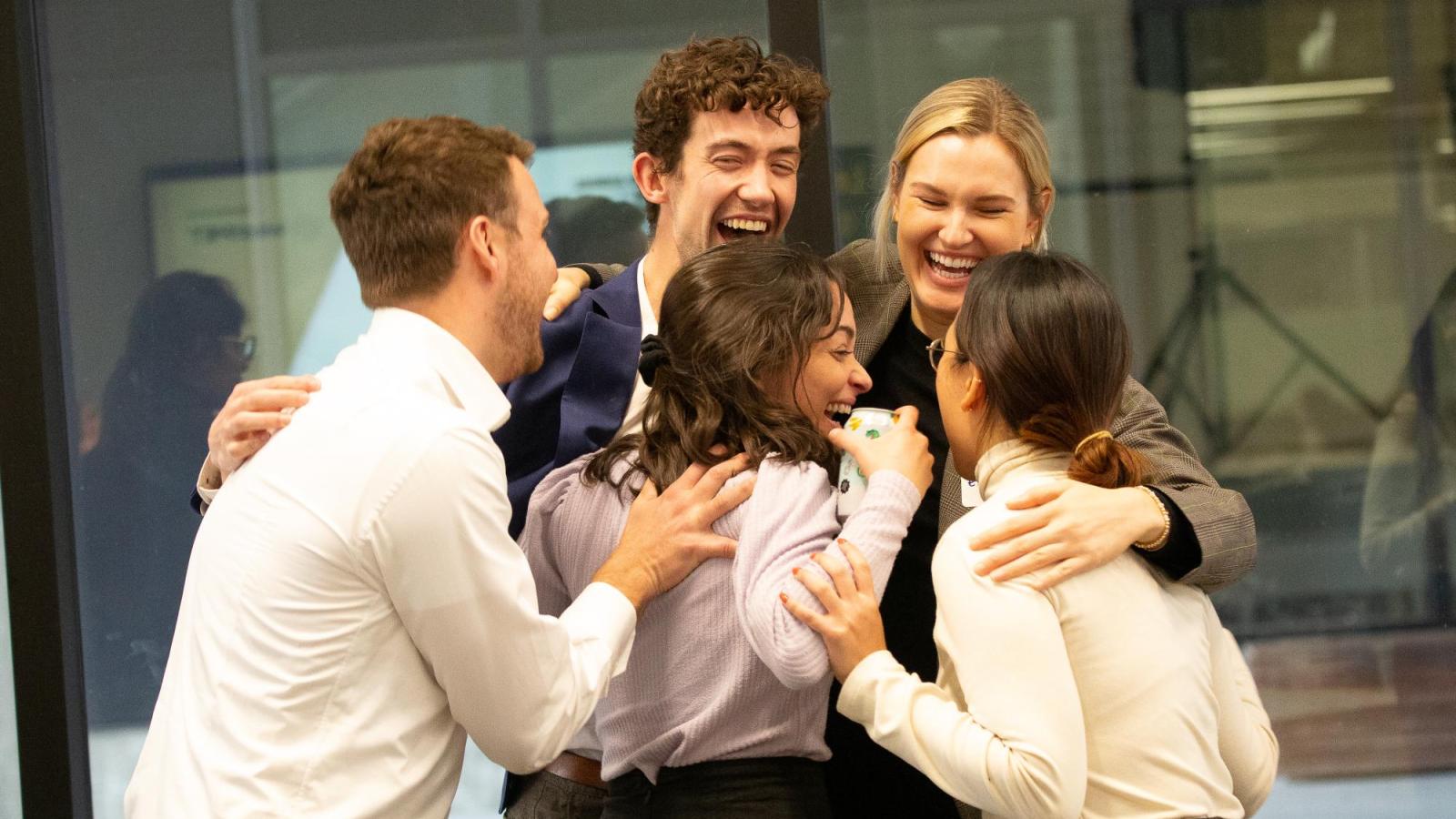 A team of students celebrate after a win in the 2023 Net Impact Case Competition.
