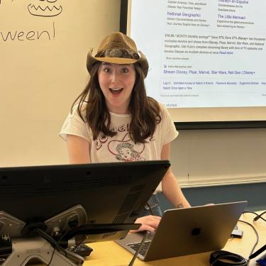 Mackenzie Culver wearing a cowboy hat in a university classroom giving a presentation.