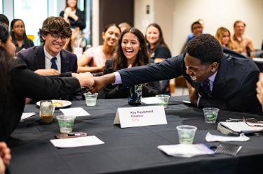 Members of the winning Business Leadership Program team celebrate their victory by fist bumping.