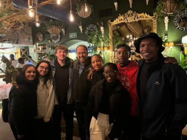 A group poses for a photo at night