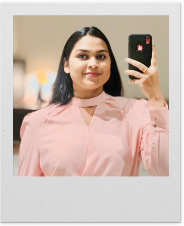 Mrudhula Rapaka show taking a smiling selfie in a polaroid-style frame