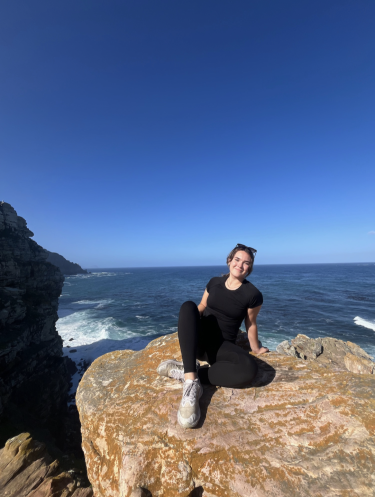 Sophie Schuler poses on a rock seaside