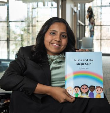 Aloukika Patro holding her book, Nisha and the Magic Coin